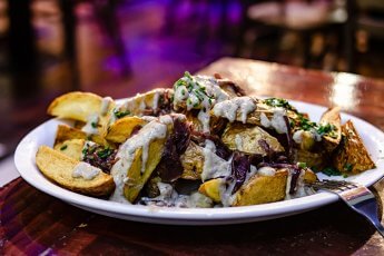 Papas rústicas con salsa de champiñones y cebolla al vino tinto